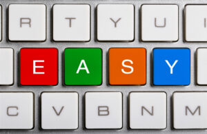 A white computer keyboard where fghi keys have been replaced with a red e a green a an orange s and a blue y key, spelling out easy