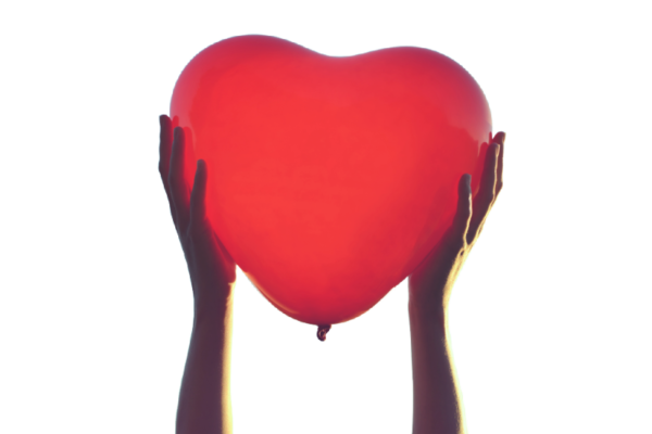 A pair of hands holds up a red heart-shaped balloon against a white background.