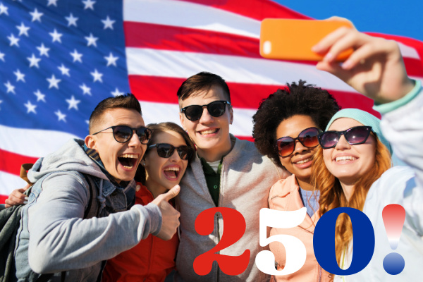 A diverse group of people take a selfie in front of an American flag.