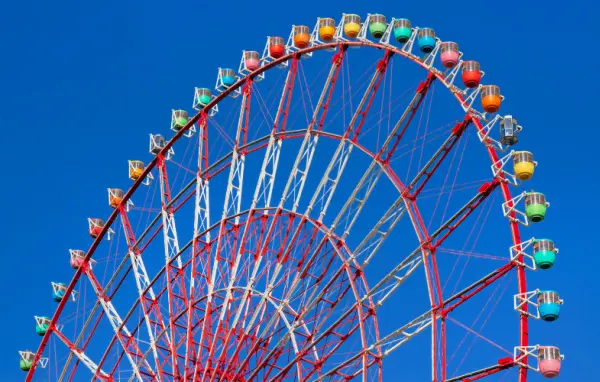 Ferris wheel in motion against a clear blue sky, representing the continuous cycle of board and commission appointments where members rotate on and off while operations continue